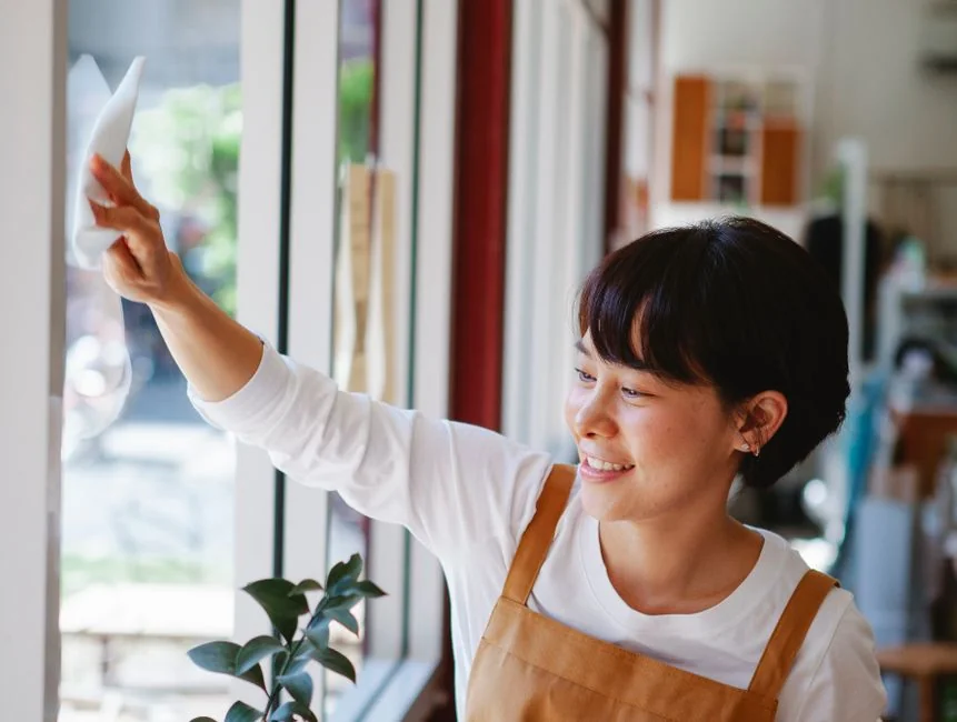 Asian couple having fun while cleaning their home, enhancing a cheerful atmosphere.